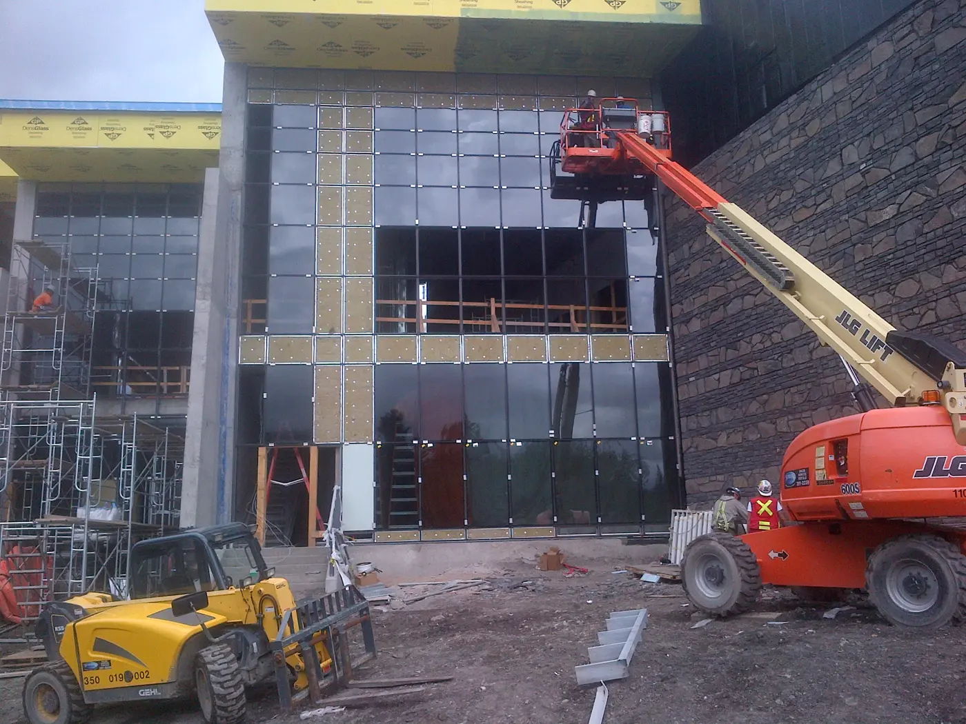 Glaziers on a boom lift installing commercial curtain wall glass
