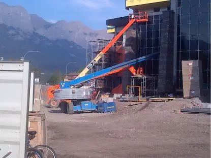 Commercial glazing site with boom lifts